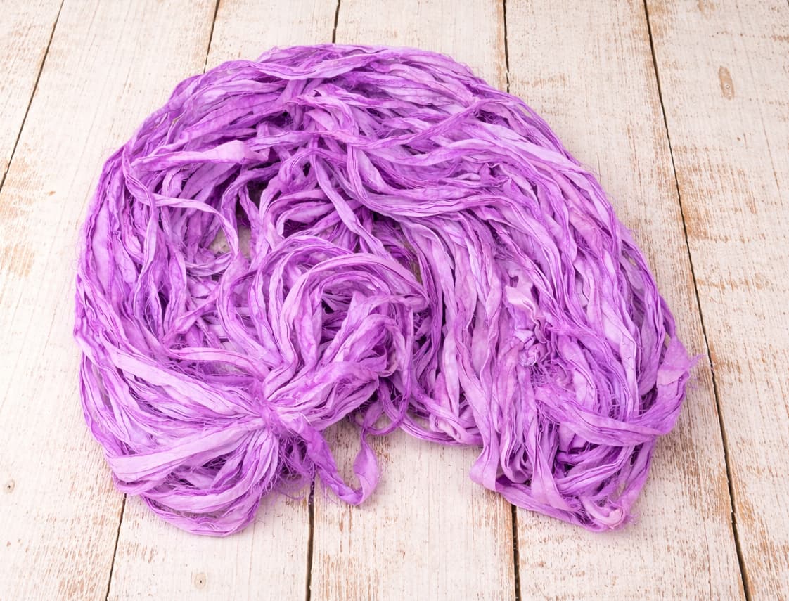 Coiled orchid purple sari silk ribbon made from recycled silk fabric.