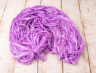 Coiled orchid purple sari silk ribbon made from recycled silk fabric.