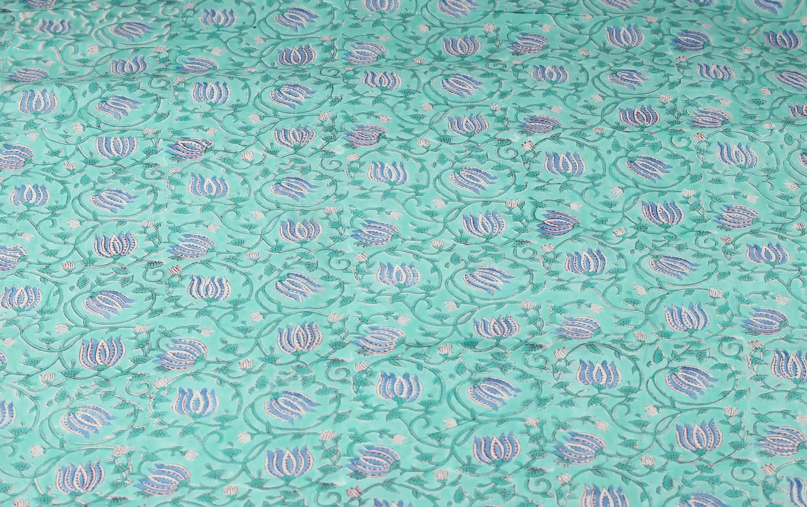 Aqua floral block print cotton fabric featuring repeating blue lotus buds and scrolling vines