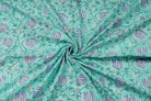 Hand block printed aqua cotton fabric draped to showcase lotus vine pattern and fabric texture
