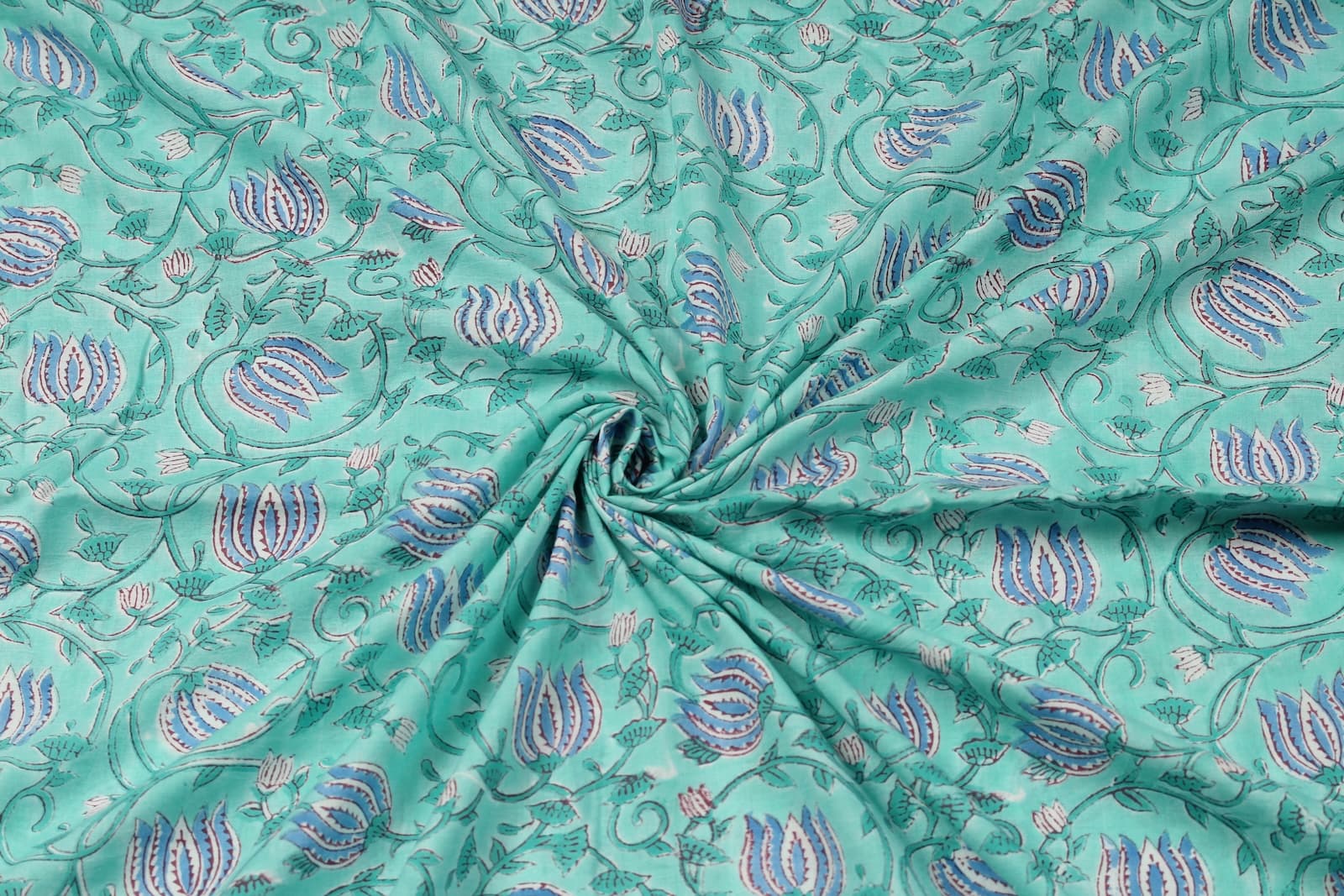 Hand block printed aqua cotton fabric draped to showcase lotus vine pattern and fabric texture