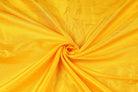 Golden Yellow Dupion Silk Fabric arranged in elegant swirling folds highlighting its luminous sheen, crisp texture, and vibrant golden colouring