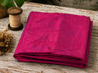 Magenta Orchid dupion silk fabric folded on a tabletop showing vibrant magenta raw silk with iridescent sheen