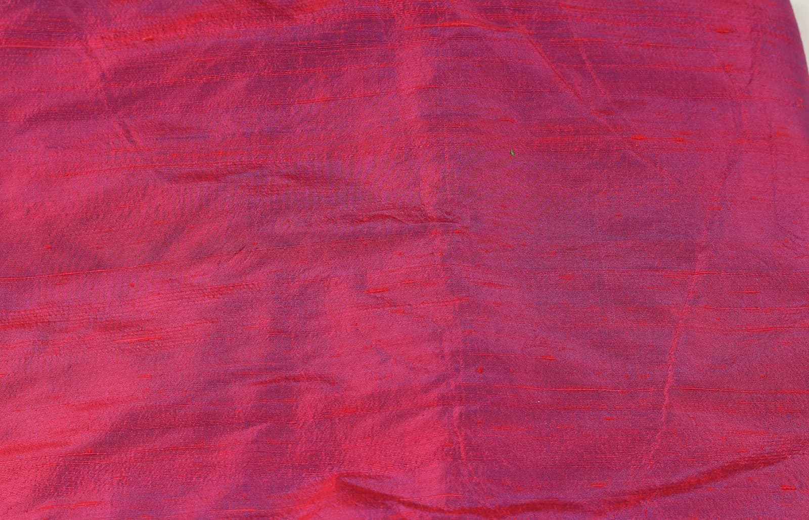 Close-up of Magenta Orchid dupion silk fabric showing raw silk texture, natural slubs, and magenta orchid iridescent sheen