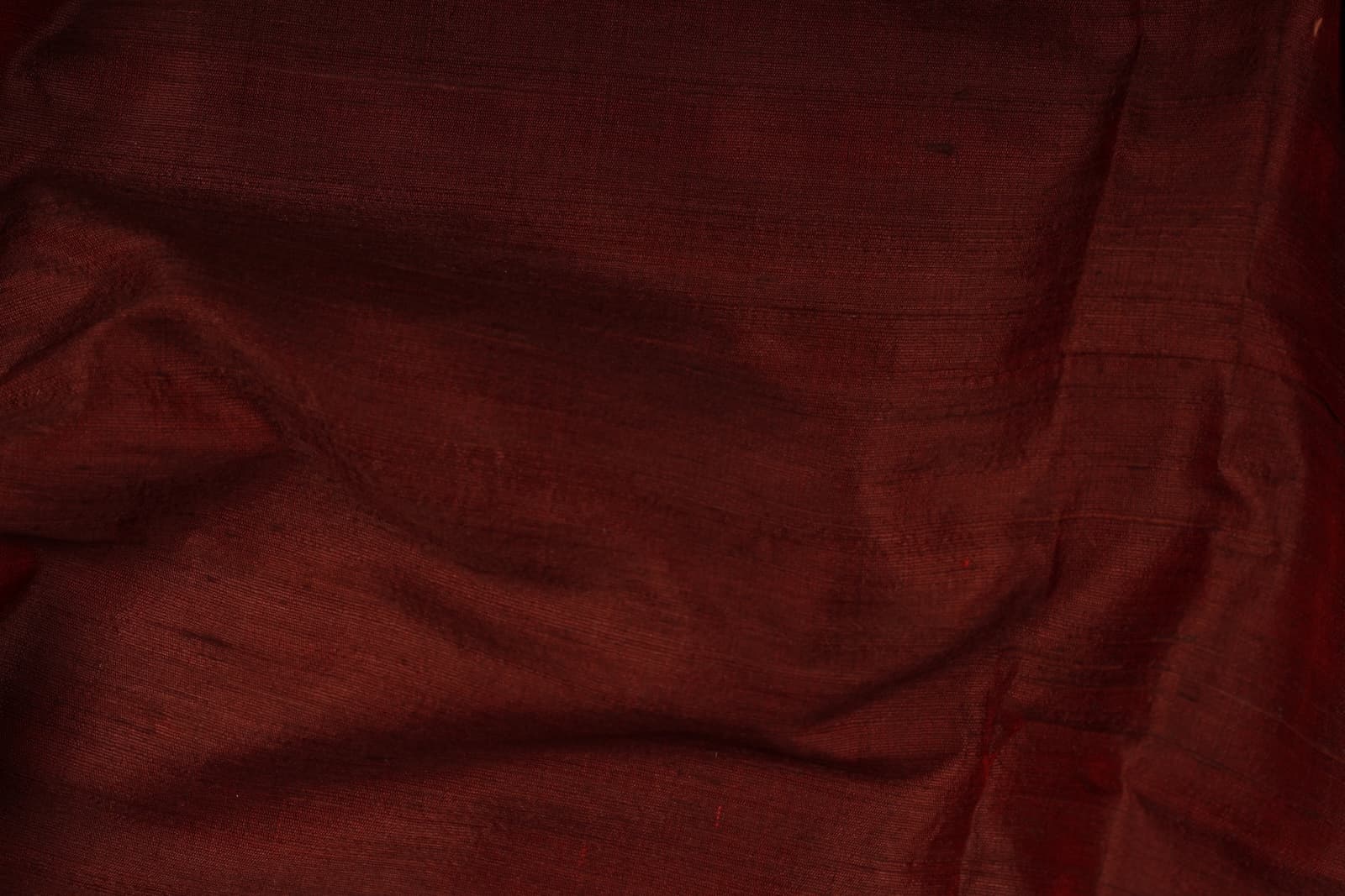 Close-up of Mahogany Burgundy Dupion Silk Fabric showing natural slub texture, woven silk detail, and subtle colour variation