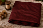 Mahogany Burgundy Dupion Silk Fabric folded to showcase its rich burgundy-red colour, natural silk texture, and elegant sheen