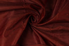 Mahogany Burgundy Dupion Silk Fabric arranged in elegant swirling folds highlighting its lustrous finish and natural dupion silk texture