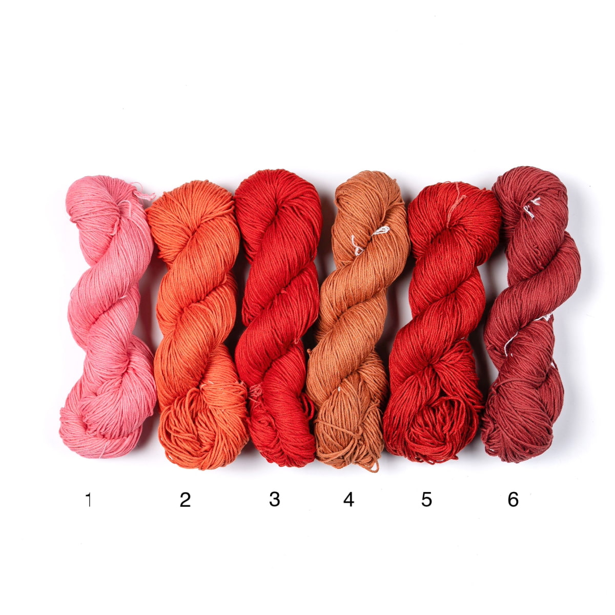 Mercerized Cotton Yarn – six shades in pink, orange, and red tones, soft lustrous 100% cotton skeins.