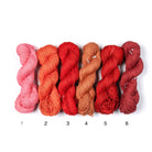 Mercerized Cotton Yarn – six shades in pink, orange, and red tones, soft lustrous 100% cotton skeins.