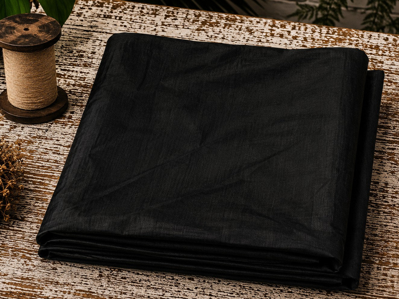 Black Dupion Silk Fabric folded to showcase its rich black colour, natural silk texture, and elegant lustrous sheen