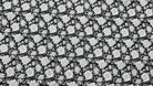Black and white botanical block printed cotton fabric with detailed floral motifs