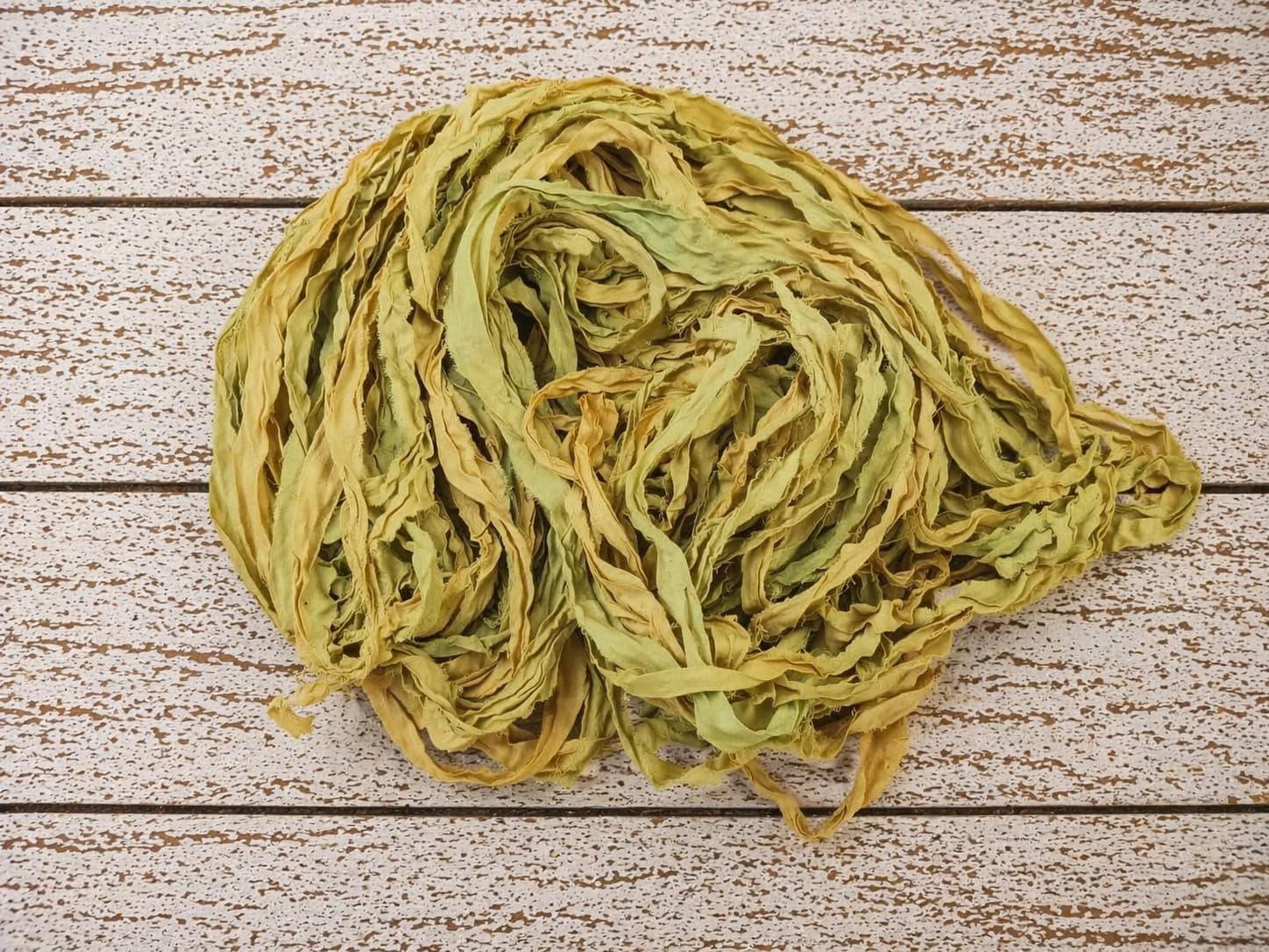 Coiled olive moss chiffon silk ribbon yarn showing soft texture and drape