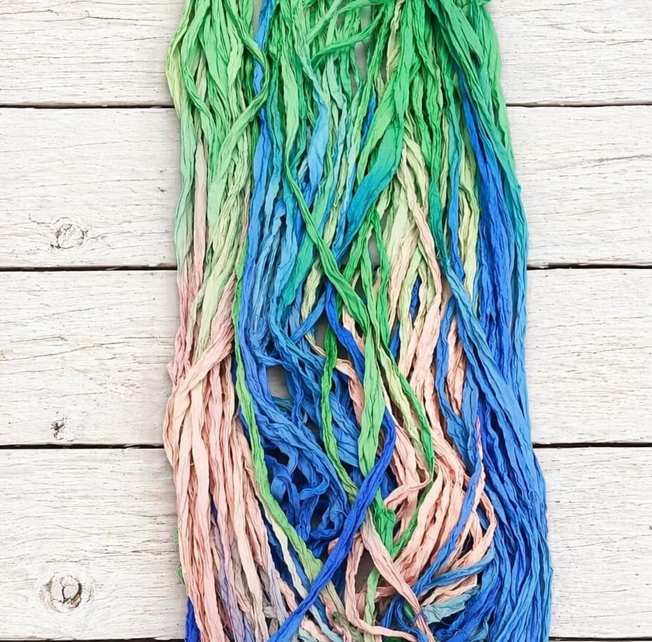 Coiled Seaside Garden sari silk ribbon yarn showing blue, green and pastel pink shades