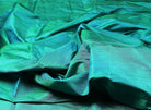 Peacock teal raw silk fabric draped to show shimmer and texture