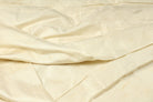 Ivory Dupion Silk Fabric displayed with soft folds revealing natural silk texture, subtle sheen, and sophisticated ivory tones