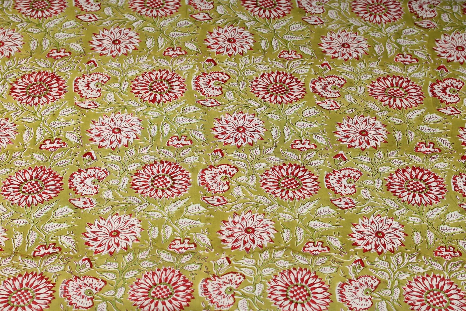 Olive Blossom block printed cotton fabric showing repeating floral pattern on olive green background
