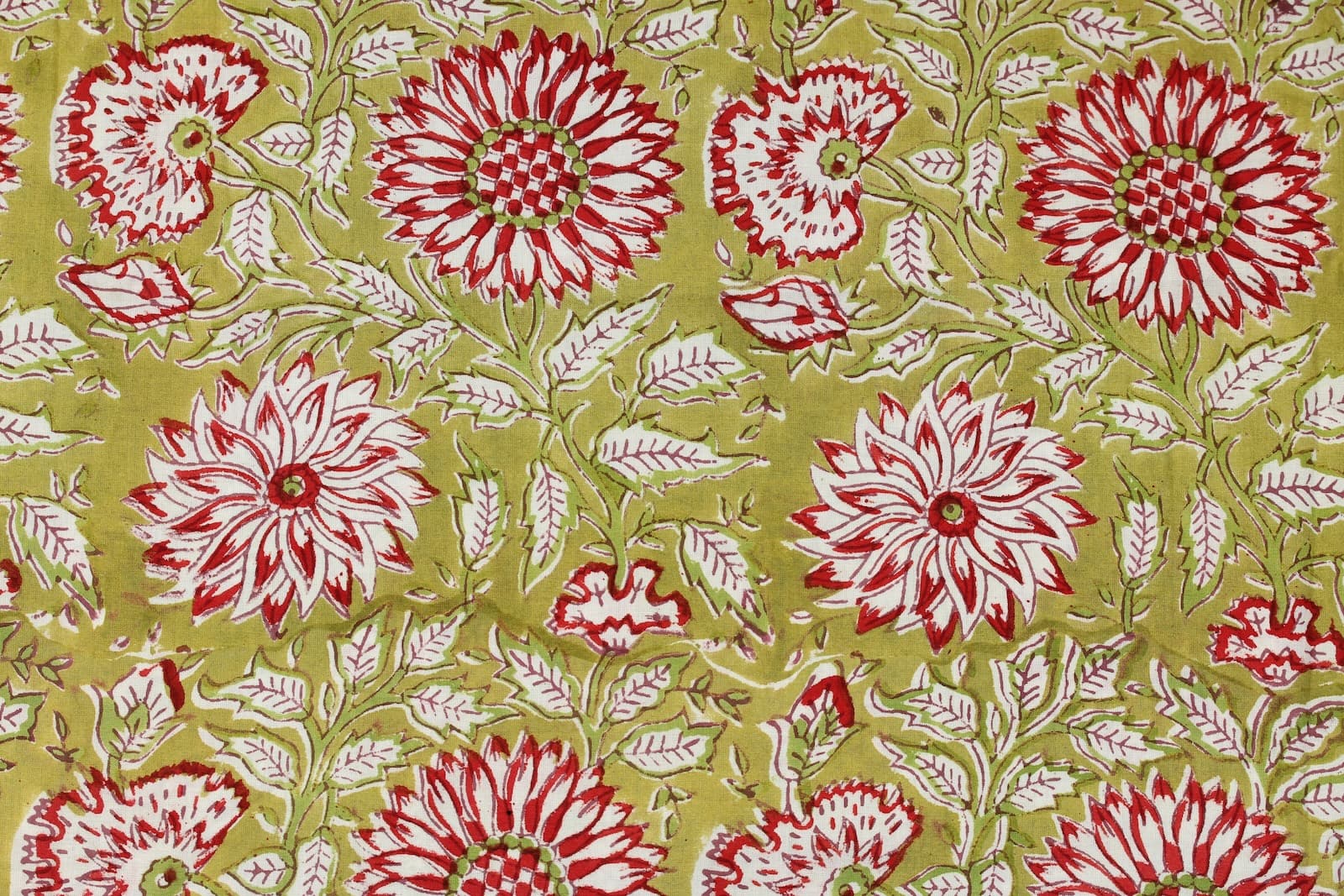 Close-up detail of Olive Blossom block printed cotton fabric showing red and white floral motifs