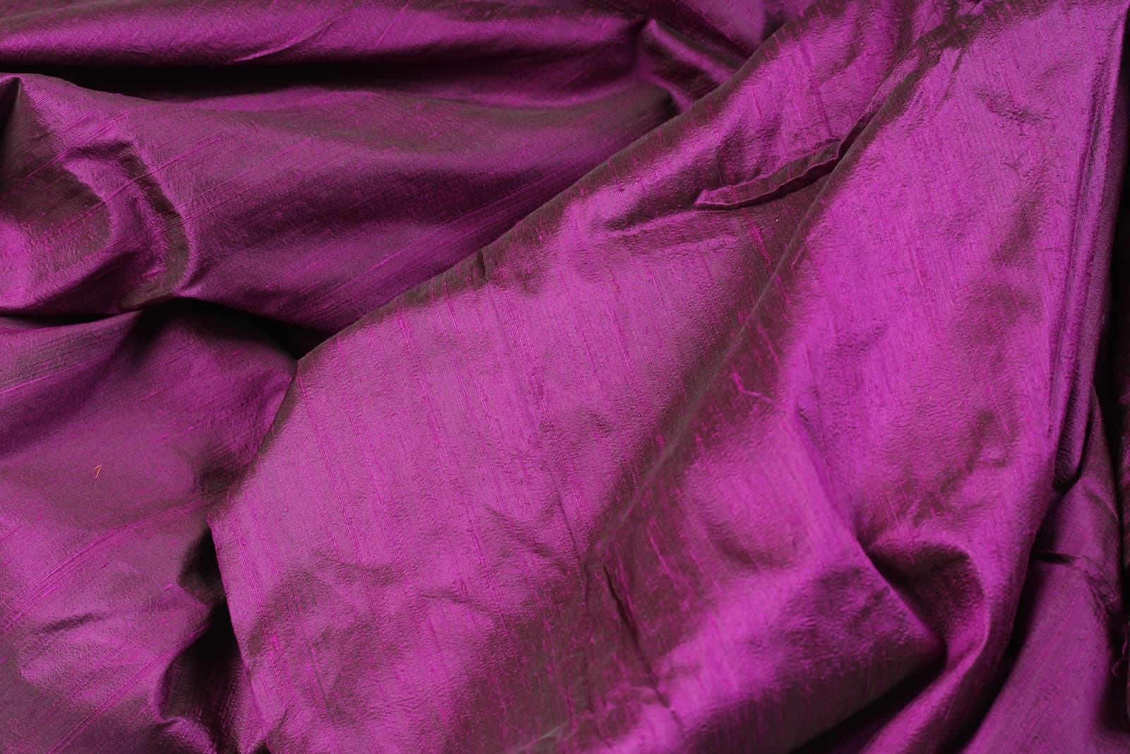 Orchid Purple Dupion Silk Fabric displayed in flowing folds highlighting its rich purple colouring, silk texture, and luxurious iridescent finish