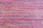 Close-up of handwoven sari ribbon fabric showing textured pastel pink, lilac, and pale blue silk ribbons.