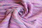 Draped handwoven sari ribbon fabric in pastel pink and lilac shades highlighting texture and weave.