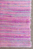 Full view of handwoven sari ribbon fabric in pastel pink and lilac tones made from reclaimed sari silk ribbons.