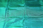 Close up texture of peacock teal dupion silk fabric with natural slubs