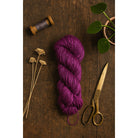 Deep purple handspun Eri silk yarn on a brown table – natural Himalayan peace silk fiber