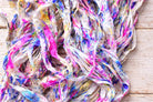 Close-up texture of Cotton Candy Confetti sari silk ribbon yarn with multicolor paint-splatter effect