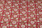 Raspberry Lotus Vine hand block printed cotton fabric featuring pink lotus flowers and green vines on a raspberry red background