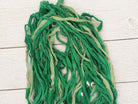 Close up of recycled silk ribbon strands in fern green and pale sage