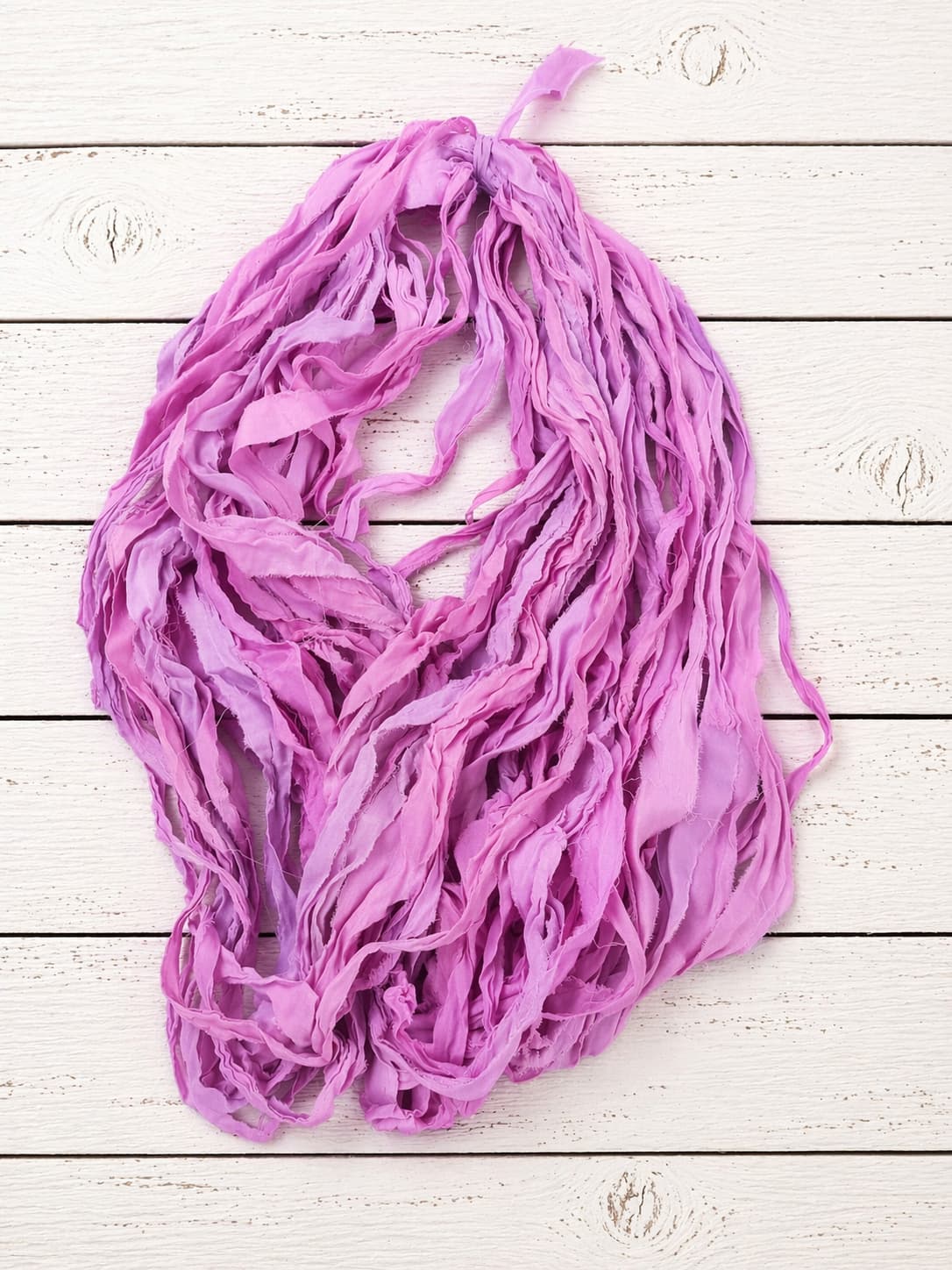 Full-length strands of Orchid Blossom chiffon silk ribbon yarn showing airy texture and soft drape