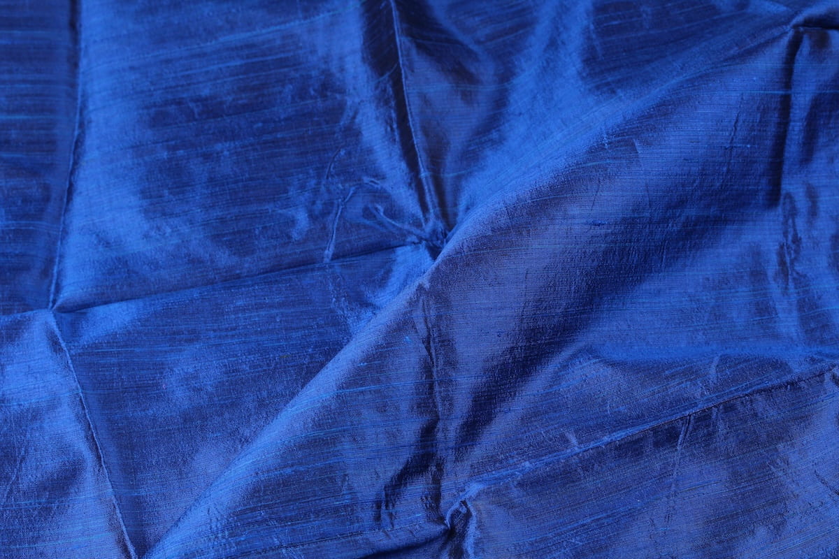 Royal Blue Dupion Silk Fabric displayed with soft folds revealing natural silk texture, lustrous finish, and rich jewel-blue colouring