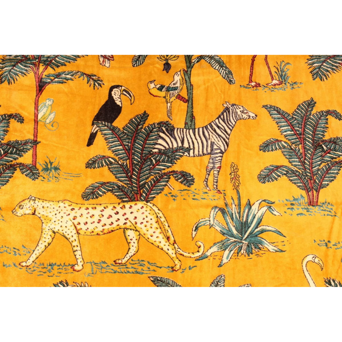 Close-up of cheetah and tropical foliage on mustard velvet fabric