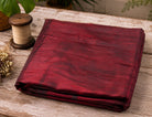 Folded ruby red Dupion silk fabric showing natural slub texture and silk sheen.