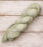 Single skein of sage green sari silk ribbon handcrafted from recycled silk fabric.