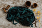 Flat lay of black and teal green sari silk ribbon with creative styling for inspiration