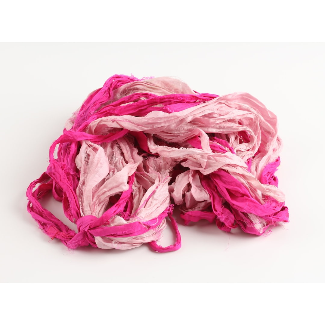 Dark pink and pastel pink sari silk ribbon opened to show handmade frayed edges and natural silk feel.
