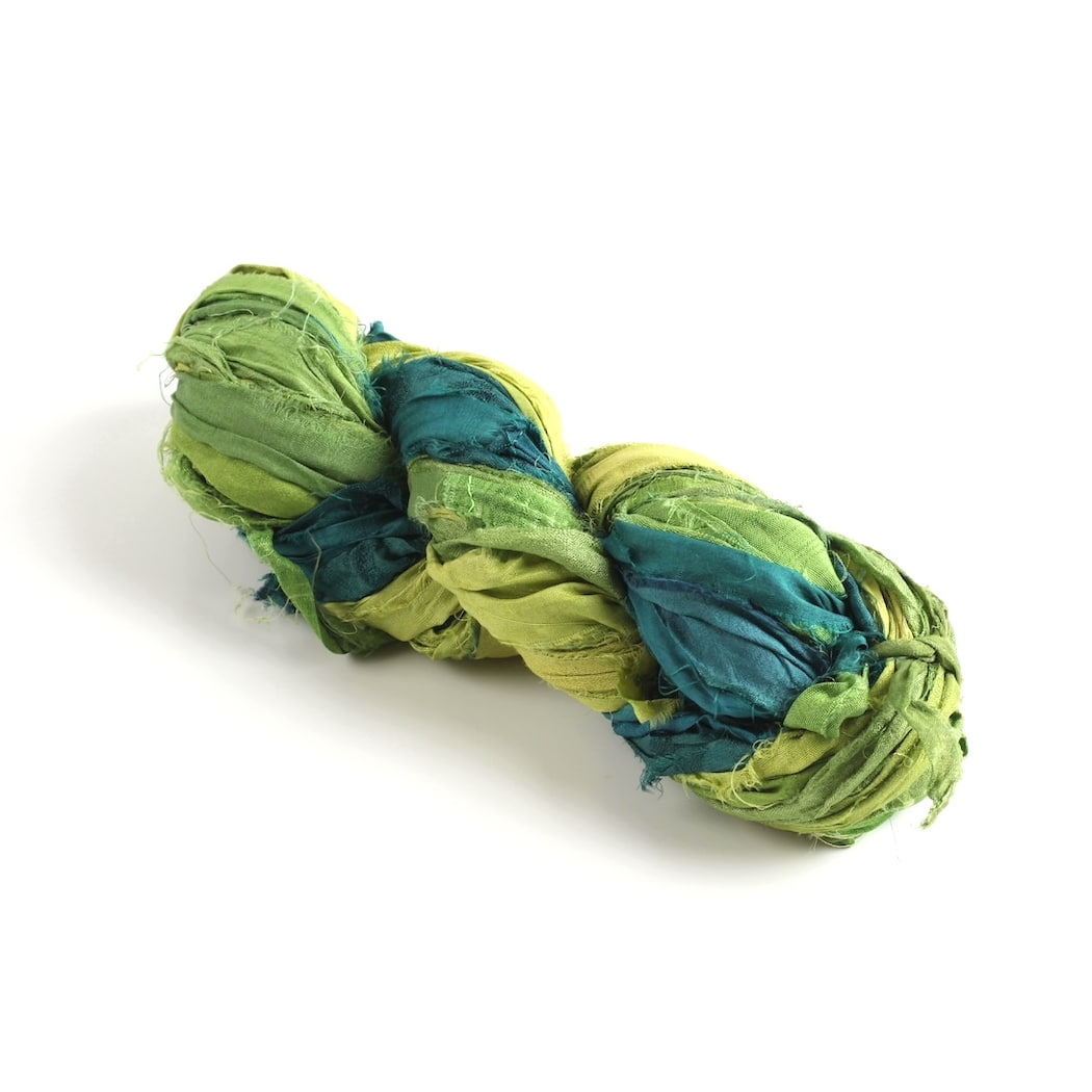Green shades sari silk ribbon skein in light, dark, and pastel tones on white background, handmade recycled ribbon.
