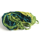 Green sari silk ribbon in multiple shades displayed open, showing frayed edges and recycled silk texture.