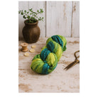 Styled flat lay of light, dark, and pastel green sari silk ribbons, handmade sustainable craft supply.