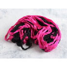 Pop pink and black sari silk ribbon opened to show vibrant color mix and texture