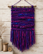 Woven wall hanging created using Jewel Tones recycled sari silk yarn in purple, pink and blue shades.