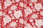 Close-up of ivory floral blossoms and botanical details on scarlet red hand block printed cotton fabric