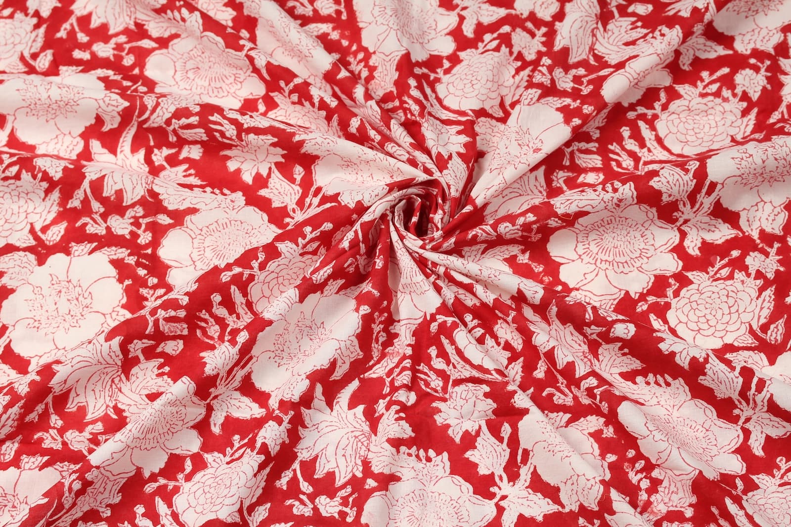 Scarlet red block print cotton fabric draped to showcase floral pattern and soft cotton texture