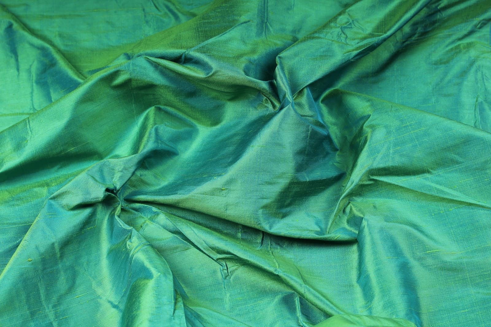 Seafoam Green Dupion Silk Fabric displayed in flowing folds showing its fresh colour and luxurious silk sheen