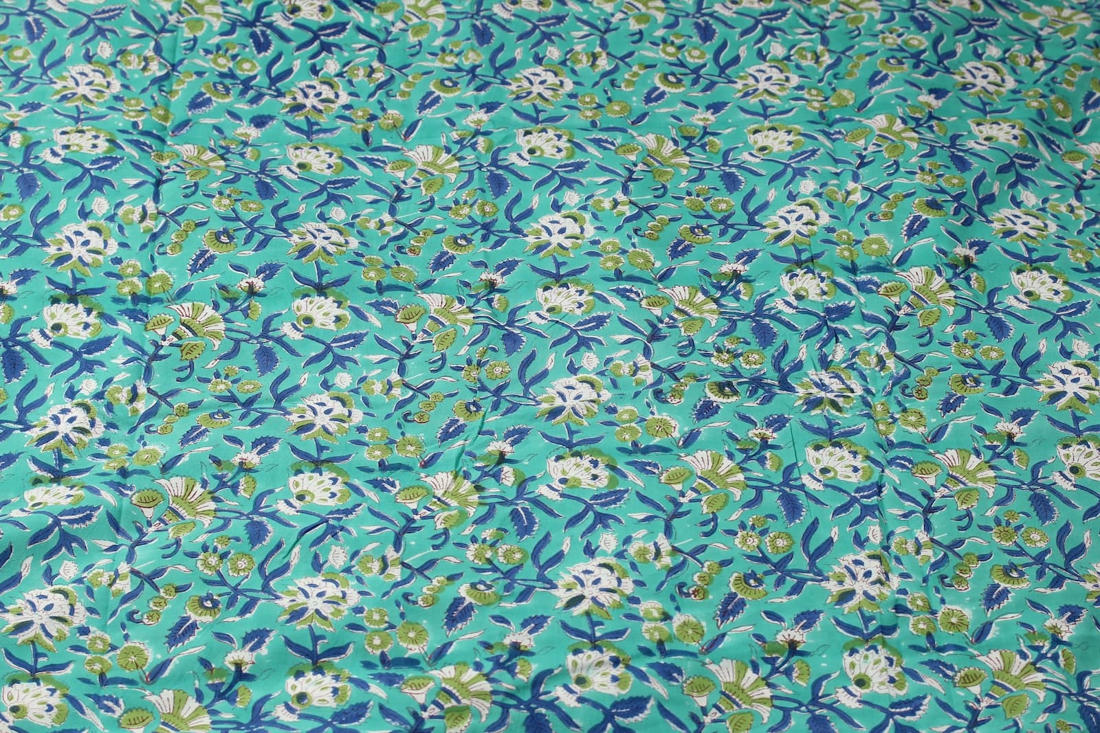 Seafoam Wildflower Trail hand block printed cotton fabric featuring ivory flowers, navy vines, and olive green botanical details on a seafoam background