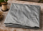 Silver Pewter dupion silk fabric folded on a tabletop showing metallic silver colour and natural raw silk texture