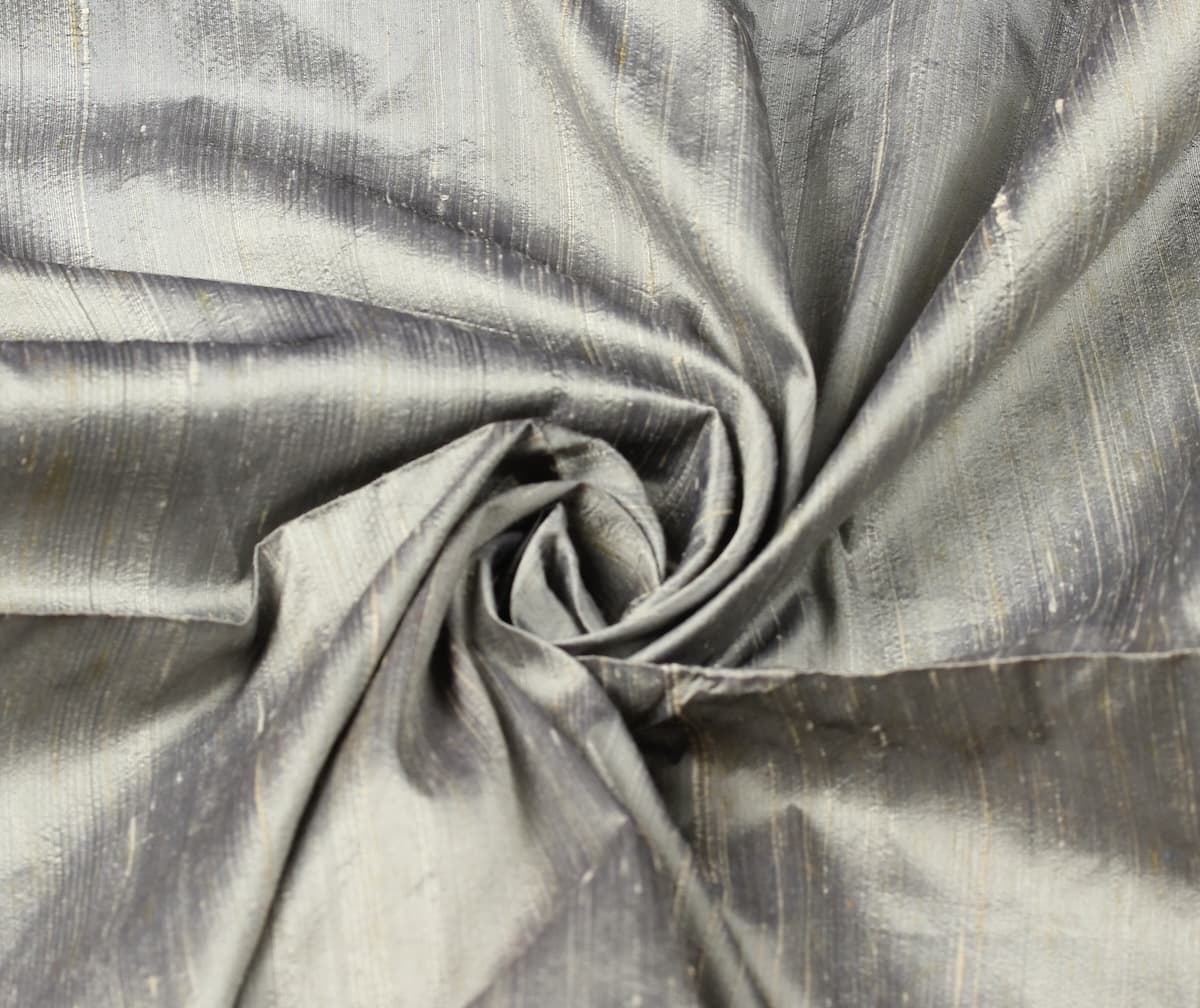 Silver Pewter dupion silk fabric arranged in a swirl highlighting metallic sheen, natural slubs, and raw silk texture