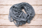 Loose hank of storm grey sari silk ribbon made from reclaimed sari silk fabric.