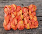 Bundle of Sunset Mango sari silk ribbon skeins made from recycled sari silk fabric.